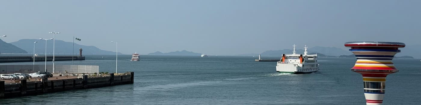 Seto Inland Sea: ferry crossing calm water near a port and art tower.